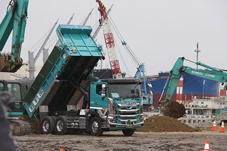 現場で積み降ろし作業中のダンプカーの写真